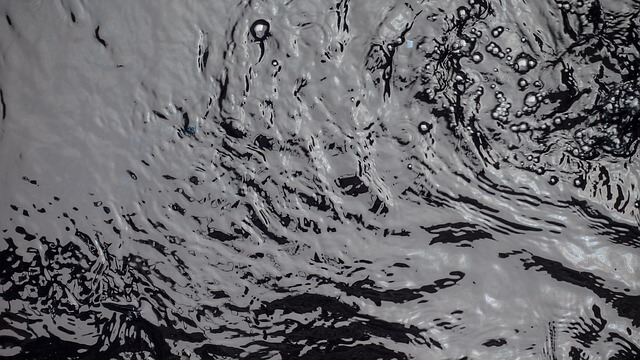 The surface of a dark pool of water, photographed from above.
