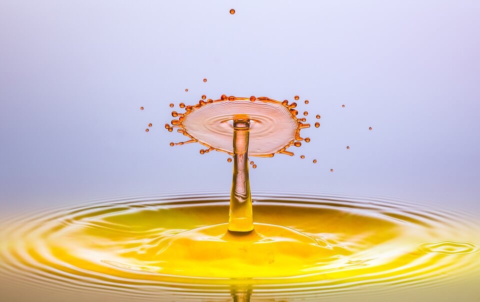 a freeze frame of a drip of yellow liquid splashing